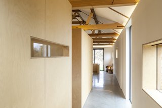 Simple plywood, cut out to allow views of the landscape, creates subdivisions within the home for private bedroom and bathroom spaces. Rather than formal rooms, they have the effect of large-scale furniture.