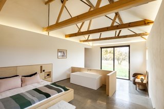 The master bedroom features an ensuite tub. "It's very utilitarian," says Witt of the barn conversion. "A lot of people want eight bedrooms, but there's no need." Agrees Smith, "The space is the luxury."