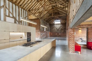The kitchen is a minimalist, functional space with Miele and Wolf appliances, Lumi joinery, and concrete worktops and sinks designed by the homeowners.