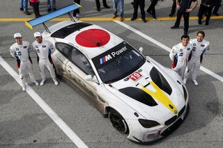 Post-race, drivers Alexander Sims, Bill Auberlen, Bruno Spengler, and Augusto Farfus pose with the muddy—but unscathed—BMW Art Car #19.