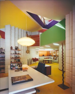 Alden B. Dow: The Mastermind of Midwestern Modernism - Photo 4 of 7 - Completed in 1941 along with the house, Dow's office is the transition point between the studio and the residence he shared with his wife Vada and their three children. Nestled down a short flight of steps, the room is an energetic and idiosyncratic study of contrasts, from the round lines of the George Nelson Saucer Pendant and the strung gourds to the sharp geometric planes of the layered ceiling. All throughout the studio and home, Dow makes use of his patented Unit Blocks, created from recycled cinder ash residue from the Dow Chemical Company coal furnaces. Here, the white rectilinear forms balance graphic colors.