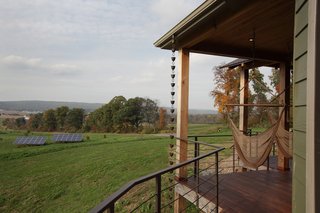 A Round Pennsylvania Prefab Offers 360-Degree Solutions in Sustainability - Photo 5 of 7 - Located outside of State College, Pennsylvania, the home enjoys rolling green vistas. Two hammocks on the porch are ideal places to take in the views or a good book. The solar array, pictured in the midground, powers the home.