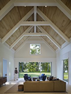 Cabins and Connectors Form a Family’s Lake Michigan Retreat - Photo 3 of 6 - Vaulted ceilings and an expansive LaCantina Multi Slide Door system in the integrated living room and kitchen creates an airy, open atmosphere. It also echoes the experience of the former home.