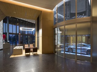 The project architect was Sieger Suarez, with interior design by Michael Wolk Design Associates and Porsche Design. Here, a glass car observatory allows a glimpse of cars as they float by on the Dezervator, named for the developer Gil Dezer.
