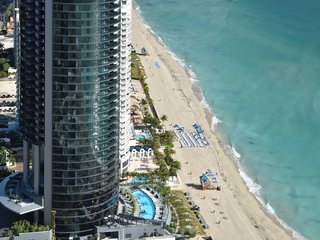 Soaring 650 feet in the air, Porsche Design Tower Miami is currently the tallest building on Sunny Isles Beach. This aerial view shows the landscaped pool deck and the sunset terrace.