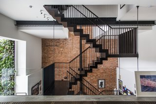 Built in the late 19th century, a former cooperage where barrels were manufactured for a local brewery now holds a bright, contemporary home that is available to rent. Entering the apartment from the street level, guests meet a dramatic, three-story atrium and a feature staircase. A glass balustrade heightens the effect. 