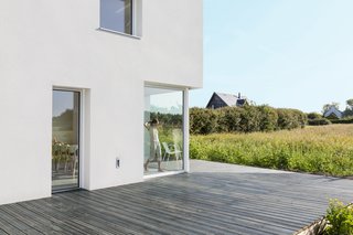 Sliding glass panels lead onto to a generous deck, which lays ensconced in the field.