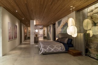 Here’s How Hollywood Builds a Malibu Dream Home—on a Vancouver Soundstage - Photo 7 of 10 - Kyle West's bedroom features an arrangement of Mori pendant lights by Rich Brilliant Willing and the Oviedo Leather Chair by Restoration Hardware, not pictured. A cloud mural painted by local artist Graeme Berglund contributes to an airy atmosphere.