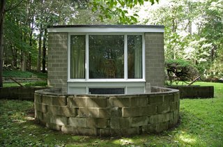 A large window from the bedroom overlooks the sunken terrace that allows the basement-level studio to open to the outside.