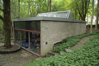 Built in the early 60s, the separate concrete-and-glass studio echoes the original home.