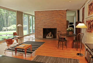Reminiscent of the Glass House, a monumental brick fireplace stands in the center of the living room. "Because the home was designed for a couple without children, it's a very large, open space that was signature of the modern experiments at the time," says Matthew. 