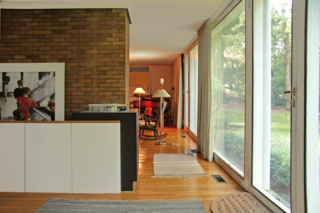The entryway leads into the living room, and a low wall hides the staircase that leads to the lower level from view.