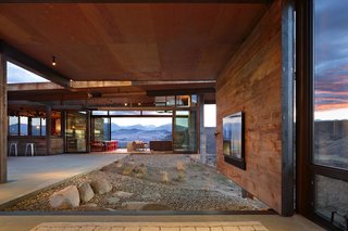 A television is mounted on a pivoting wall that can either face the indoors or out toward the courtyard, emphasizing the entertainment aspect of the home.