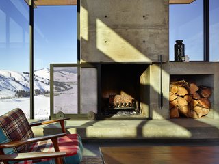 A sliding mesh screen glides over the fireplace, which features a built-in cubby for a stockpile of wood.