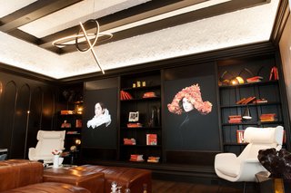 Everything in the "Bibliotheek"—from the modular leather pleated sofa, to the light fixtures, to the screen-printed portraits on light boxes, were custom-designed by Martin Kobus Home. "The library is a layered tale of dark and light, and a study in contrasting classic and modern," says Kobus.