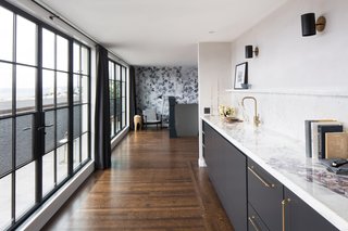 For the entry, artist and textile designer Stevie Howell painted over custom wallpaper, allowing the drips to cover the wall before drawing on the surface with charcoal.