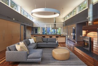 An Accessible Home Promotes a Lifetime of Well-Being For the Whole Family - Photo 1 of 7 - Walnut floors run throughout the home, creating a seamless transition between the living room and open kitchen. Clerestory windows placed throughout the residence not only allow light to permeate the space, but also cater to Langley's and Boelyn's perspectives as they lie on their backs.