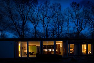 Generous stretches of glass allow the house to glow at night.