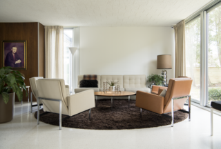A Knoll Parallel Bar Sofa, Lounge Chairs, and Coffee Table outfit the living room along with a Nessen Studios Torchiere Floor Lamp. 