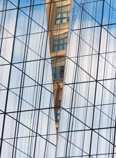 Read Between the Facades. "A modern glass and concrete building with a mirrored facade detail, quoting like a good architectural neighbor the building across the street," says Olic.