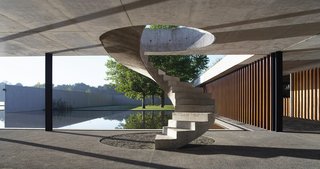 Buenos Aires-based Estudio Ramos designs a concrete, wood, and iron stable that houses 44 prized horses and melds with the surrounding plains. Made of exposed cast concrete and local hardwoods, the structure pays homage to three master architects. Ludwig Mies van der Rohe’s sharp lines are apparent throughout the project, while the walls and a connecting reflecting pool were influenced by Luis Barragán. The interplay between light and concrete is a nod to Tadao Ando. 