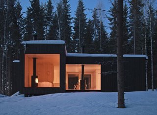 Shaped like a cross, this four-cornered villa offers four different views of its location on an island in Finland. Avanto Architects created a black exterior, dotted with large windows, to make it invisible from the nearby lake.