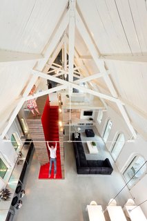 Located in Harrlo, The Netherlands, this home was once the Dutch Reformed Evangelism Building before being transformed by Leijh Kappelhoff Seckel van den Dobbelsteen architecten. The new design includes a bedroom and bathroom loft with modern features and furnishings paired with many of the original details, including the wood roof and the arched stained glass windows.