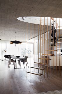 An elliptical concrete stair forms the pivot point of each floor of the house, anchoring them to the steep escarpment; the stair also wraps around a lift core that descends, mineshaft-like to link the rest of the house to the garage level.