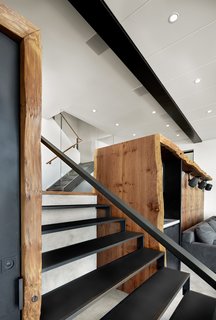 Top 5 Homes of the Week With Top-Notch Woodwork - Photo 2 of 5 - The custom steel stair by Metropolis Metalworks serves as the centerpiece to the space. The live edge burled Redwoods slabs covers the listening area and wetbar. In the distance, the stair leads up to the rest of the home and more everyday life.