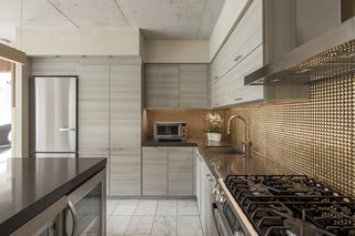 Like glass, metallic backsplashes help reflect light in a kitchen. No matter what shade you choose—whether it be silver, gold, or bronze as shown above—these metals will keep the space airy and bright while making your kitchen feel warm and luxe.