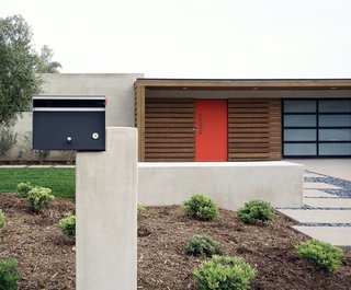 An asymmetrical mailbox incorporates midcentury geometry and new building materials into the front approach.