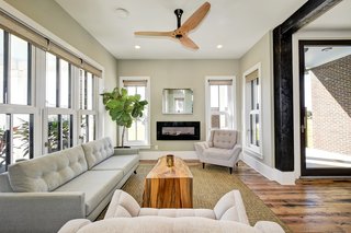 Windows and natural light surround the living room with a locally made Haiku Home ceiling fan.