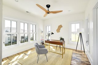 One of the bright and airy bedrooms, currently used as an office space, features a Haiku Home ceiling fan.