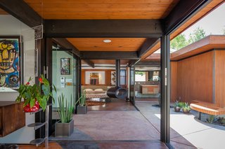 Looking from the Living Room addition across the extended Entry addition to the downstairs Master en Suite addition with back of the newly built carport on the right. Suspended fireplace by Brisach with all sliding doors including sliders that disappear into wall pockets by Fleetwood.