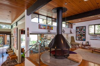 Story and a half Entrance on left with living room on same level. Up a split level is the Family Room. Engineered Hickory/Pecan wood throughout with polished concrete floors and mantle for original Fireplace. Built in shelving to display books horizontally on right most wall with accompanying framed display of ashtrays from all over the world dating back to the 1960's.