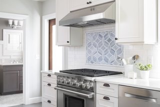 A custom backsplash was designed using Ann Sacks tile which compliments the marble countertop and accentuates the Wolf range.