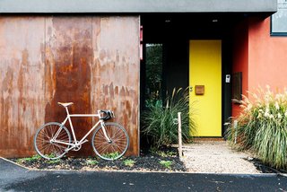 For a more colorful approach to creating curb appeal, you can use two or more shades to build a personalized color story between the front door and the exterior of the house. Combining warm citrus tones gives this home an extra zing.