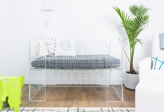 Little Crown Interiors inserted a transparent crib into this Los Angeles nursery—along with a clear changing table and side table. Pops of green and blue almost glow in comparison to the transparent surfaces.