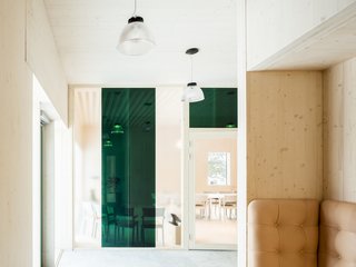 The interior design is characterized by restraint. Wood complements leather and concrete for a modern, natural-looking building that blends together with its lush surroundings.