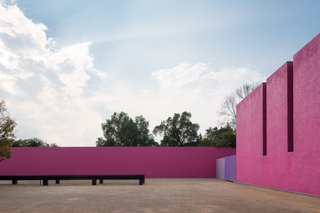 A Cuadra San Cristóbal courtyard surrounded by vibrant pink walls.