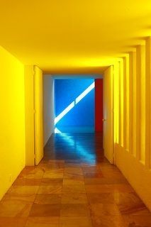 Only one wall in the pool corridor at Casa Gilardi is yellow; the other is white. Light enters via the adjacent courtyard, resulting in a warm glow.