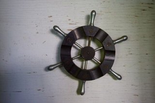Mini ship wheel mounted inside of bookshelf 