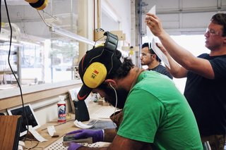 Sean showing us the sanding process as Alex Boepple and Misbah Afshari do finish work.