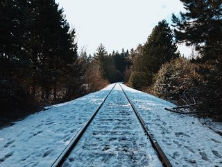 Icy foot tracks mark this snow-pelted section of railroad track.
