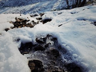 Ice and snow crust a rocky embankment.
