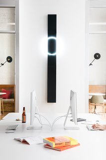 Figma's SF Office Celebrates the Humanity of Work - Photo 3 of 7 - Large white desk space is set against dark and neon wall art with accents of plywood.