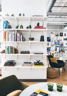 Figma's SF Office Celebrates the Humanity of Work - Photo 4 of 7 - Open shelving and books with a sea of posters in the rear brings color and life to the sea of whites, grays, and light wood flooring.