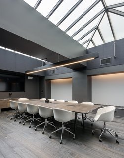 This large conference room breaks from the black and white theme to create a sea of warm neutrals flooded with natural light from above.