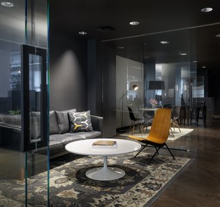 Touches of warmth are added to this dark space with dynamic lighting to breathe life into the room.
