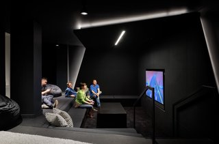 A black room with stunning geometry creates the perfect spot to chill and play some video games.